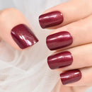 Close-up of a hand with burgundy nail polish on a light background, Obroi
