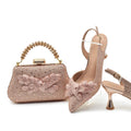 Pink handbag and high-heeled shoes with floral details on a white background, Obroi