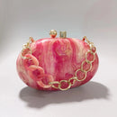 Pink marbled clutch with gold chain on a light gray background, Obroi