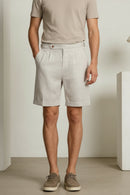Person wearing light-colored shorts and brown shoes in a minimalistic setting, Obroi