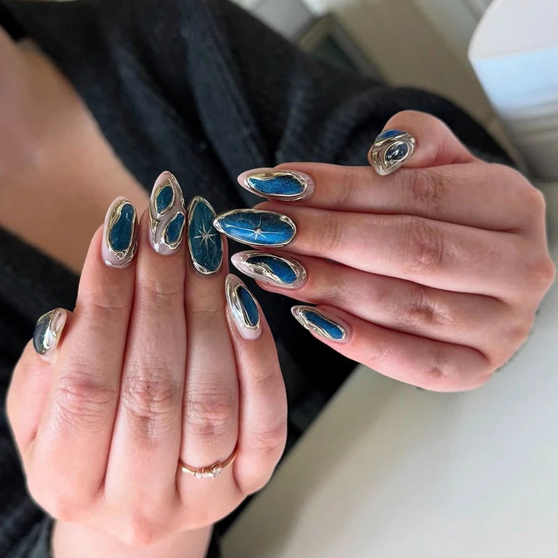 Close-up of hands with decorative blue and silver nail art on a neutral background, Obroi