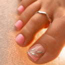Close-up of a hand with pink nail polish and a silver ring on a neutral background, Obroi