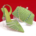 Green high-heeled shoe and matching clutch with gemstones on a red background, Obroi