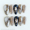 Set of decorative nails with a mix of silver, gold, and black on a white background, Obroi