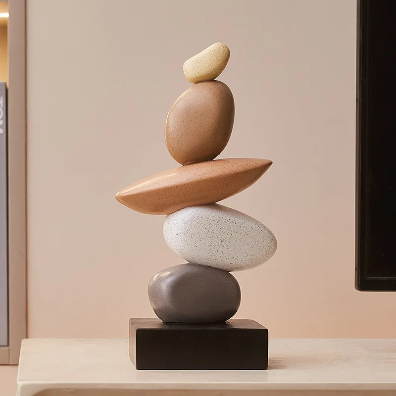 Stack of balanced stones on a black base against a neutral background, Obroi