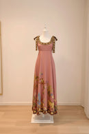 Pink floral dress on a mannequin against a plain wall, Obroi