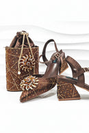 Brown high-heeled shoes with embellishments and a matching handbag on a white background, Obroi