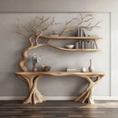 A rustic, tree-inspired wooden console table and floating shelves set against a light gray wall, styled with books, vases, and a small floral arrangement, Obroi
