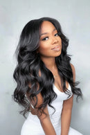 Woman with long, wavy black hair wearing a white top against a light gray background, Obroi