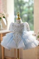 Elegant light blue dress with silver embellishments on a mannequin against a blurred indoor background, Obroi