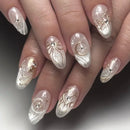 Nails with decorative gold and silver designs on a neutral background, Obroi