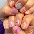 Close-up of hands with pastel marble nail design, Obroi