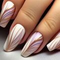 Nails with decorative design featuring gold and white patterns on a neutral background, Obroi
