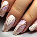 Nails with decorative design featuring gold and white patterns on a neutral background, Obroi