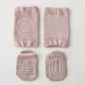 Set of four pink baby socks with textured patterns on a light gray background, Obroi