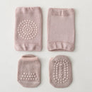Set of four pink baby socks with textured patterns on a light gray background, Obroi