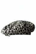 A structured flat cap with a black and off-white spotted pattern, resembling a dalmatian print, shown against a plain white background, Obroi