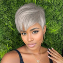 Woman with short gray hair against a green leafy background, Obroi