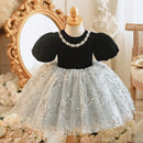 Black top with white lace skirt on a mannequin against a decorative background, Obroi