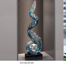 Obroi decorative glass sculpture with wavy design on a stand in a room setting.