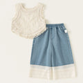 White sleeveless top with lace details and blue denim shorts with lace trim on a white background, Obroi