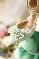 White high-heeled shoe with floral decorations on a blurred background, Obroi