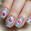 Nails with floral design featuring pink flowers and blue accents on a neutral background, Obroi