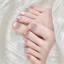 Close-up of toes with pink nail polish and decorative elements on a white background, Obroi