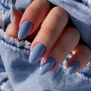 Close-up of a hand with blue nail polish wearing a denim jacket, Obroi