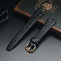 Black textured watch strap with gold buckle on a dark surface, Obroi