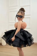 Child wearing a black dress with pink floral top and sunglasses against a neutral background, Obroi