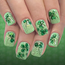 Green nail art with shamrock designs on a matching green background, Obroi
