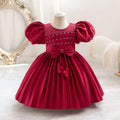 Red dress with puff sleeves on a mannequin against a decorative background, Obroi