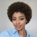 Woman with short, curly hair wearing a light blue shirt against a gray background, Obroi