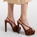 Brown high-heeled sandals worn with a light-colored skirt on a neutral background, Obroi