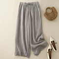 Gray wide-leg pants with a woven bag and white shoes on a beige background, Obroi