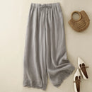 Gray wide-leg pants with a woven bag and white shoes on a beige background, Obroi