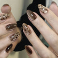 Nails with brown and gold leopard print design on a neutral background, Obroi