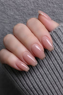 Nails with a pink and gold glitter gradient on a textured surface, Obroi