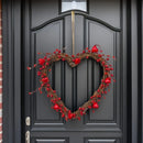 Heart-shaped wreath with red berries on a black door, Obroi