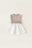 Children's outfit with a mauve top and white skirt on a beige background, Obroi