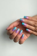 Hands with pastel gradient nail art on a plain background, Obroi