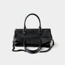 Black handbag with gold hardware on a white background, Obroi