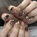 Close-up of hands with brown and gold nail art on a neutral background, Obroi