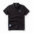 Black polo shirt with a small logo on a white background, Obroi