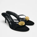 Black high-heeled sandals with gold accents on a white background, Obroi