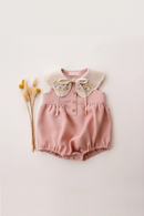 Pink baby romper with floral collar on a light pink background, Obroi