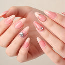 Close-up of hands with pink nail polish and decorative rhinestones on a neutral background, Obroi