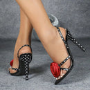 Black polka dot high heels with red rose design on a gray background, Obroi
