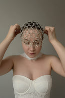 Woman wearing a decorative headpiece with beads against a neutral background, Obroi